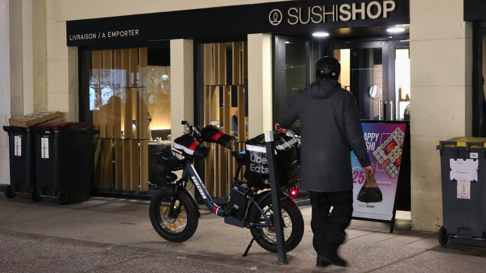 Un livreur Uber Eats s'apprête à ranger une commande dans son sac.