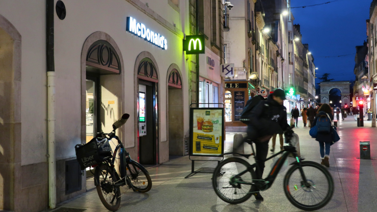 Un livreur part son son vélo après avoir récupéré une commande